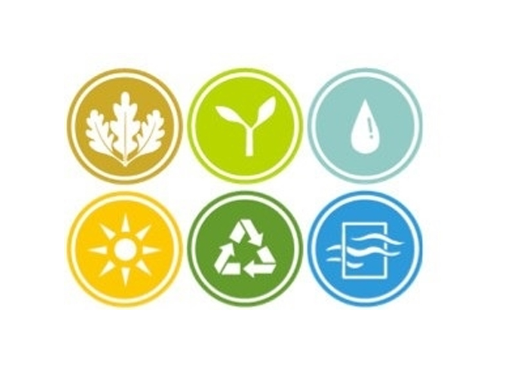 Abstract design with a gradient from yellow to green to blue. On the left, two circular icons: the top shows a tree or plant silhouette, and the bottom features a sun with rays. The image relates to nature, the environment, or energy sources.