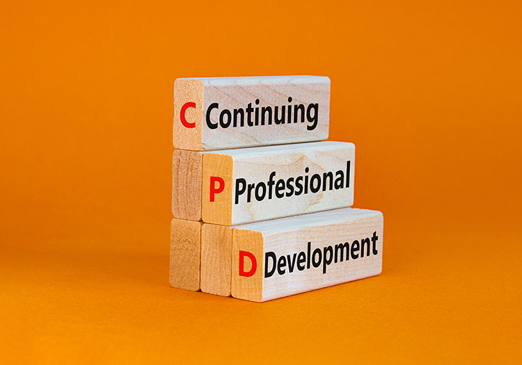 Three stacked wooden blocks with the words 'Continuing Professional Development' written on them, with the initials 'C,' 'P,' and 'D' in red, set against an orange background